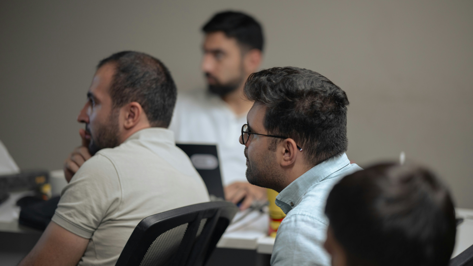 A group of office employees taking part in a group English language coaching session.