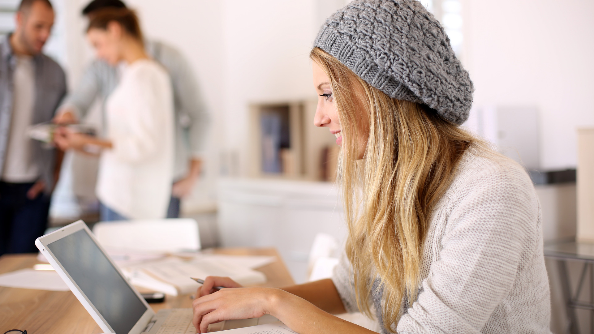 A young University student completing her studies on a laptop with expert Writing Support